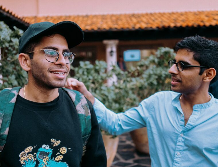 Two adult men talking while walking outdoors
