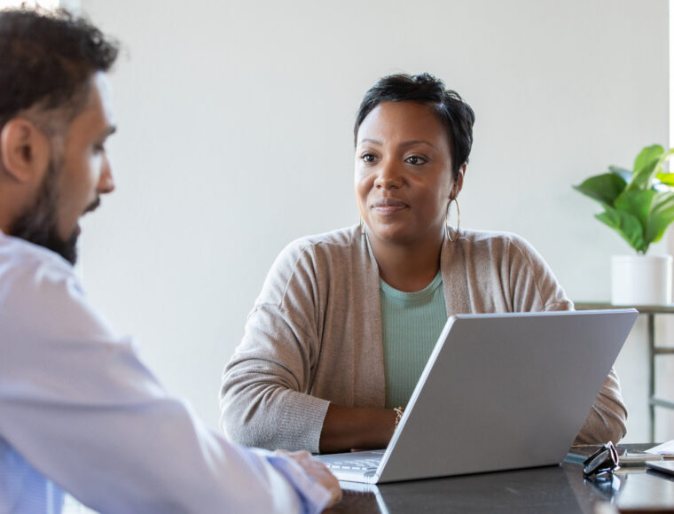 Professional woman talking with a young man in an office