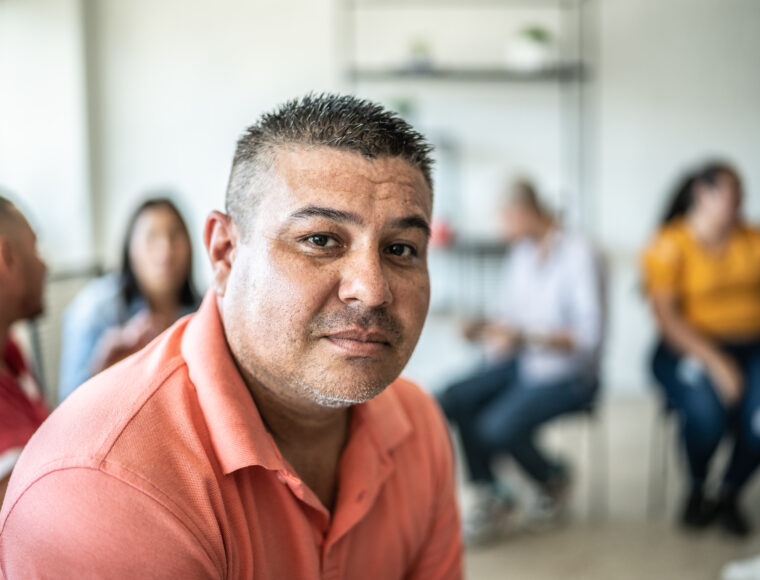 Portrait of mid adult man during a group meeting discussing mental health