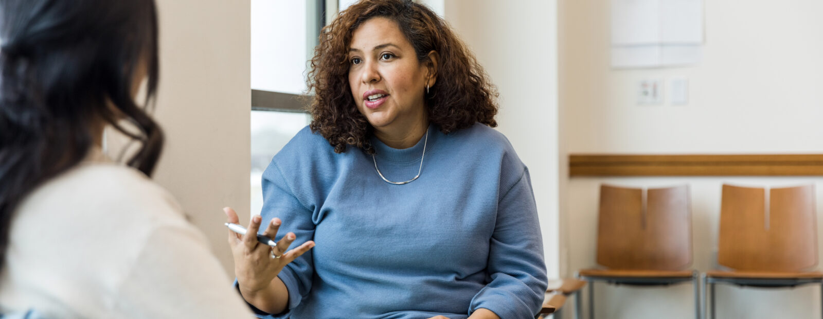 Female therapist gestures while talking with the unrecognizeable woman