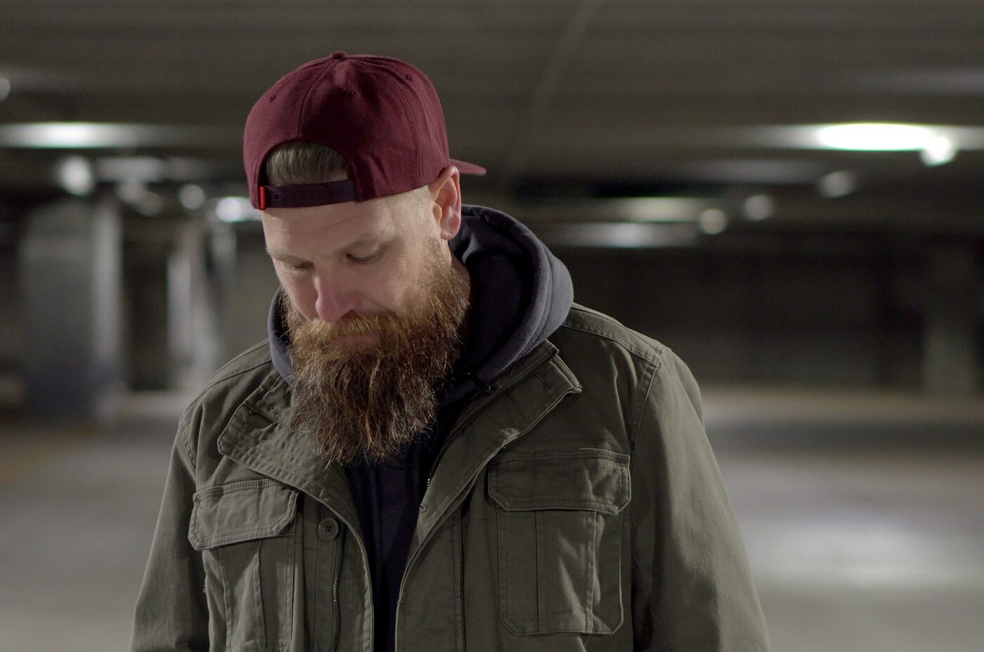 Photo of a man wearing and jacket and a baseball hat